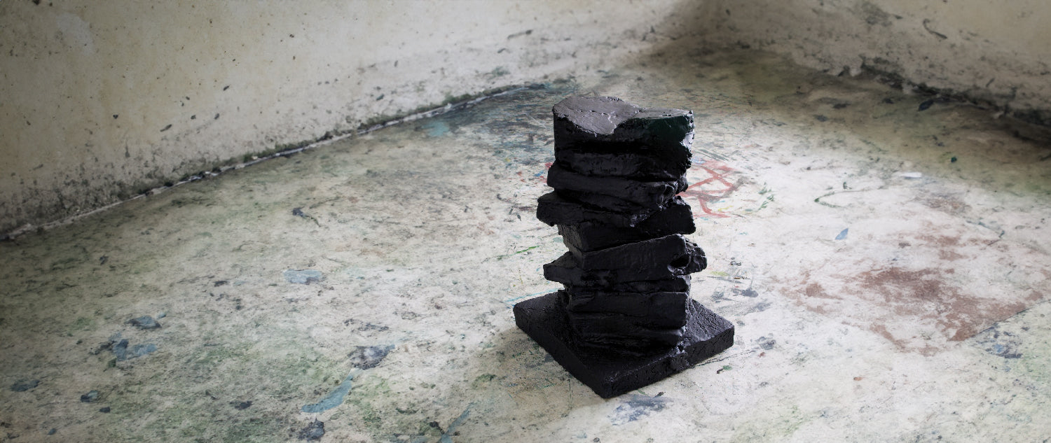 Sort skulptur på slidt gulv, Parafrase kunst af Peter Ejlerskov
