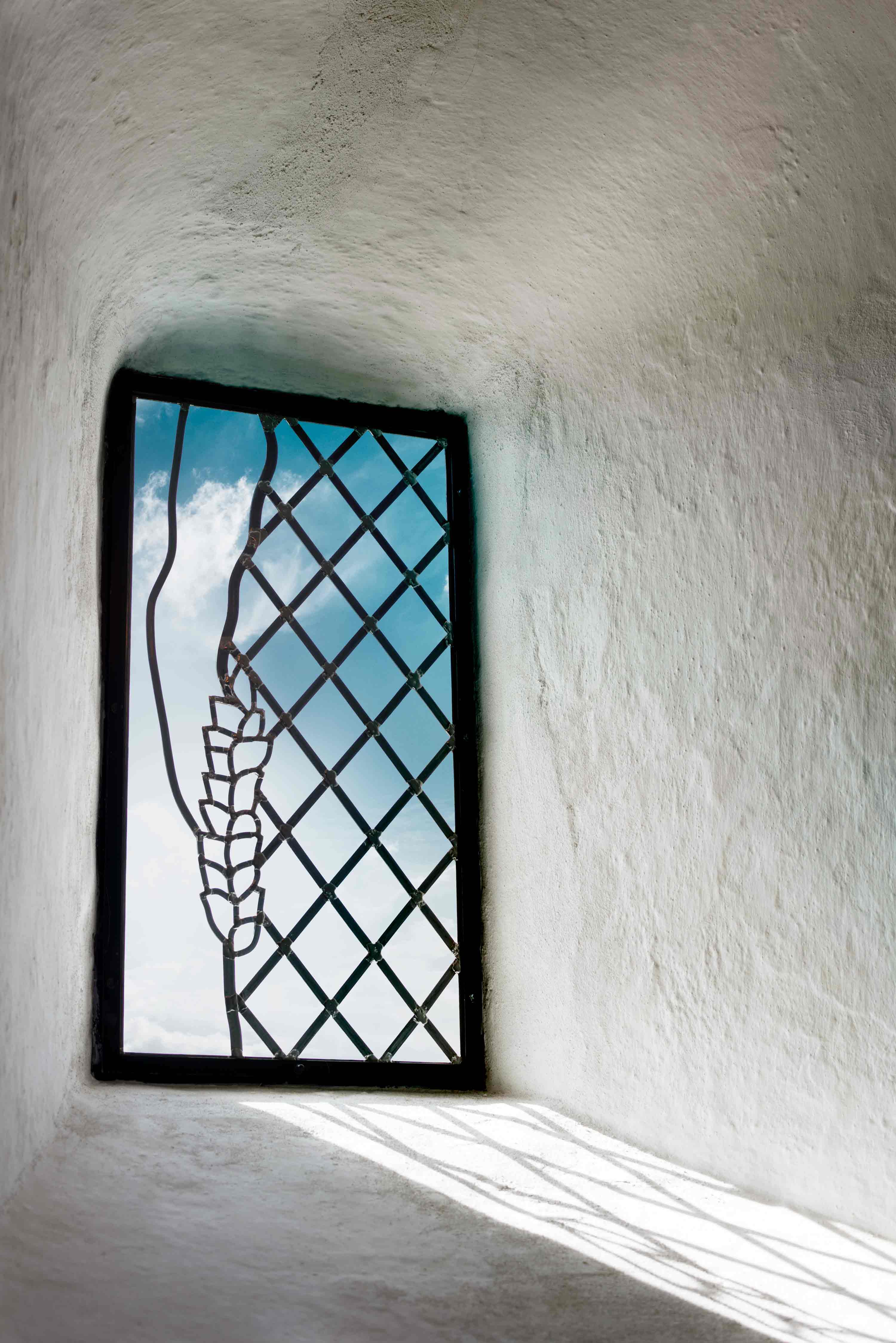 Kirkeudsmykning af Sdr Rind Kirke - Mosaikvindue med kornaks i hvid kirkevæg, kunst af Peter Ejlerskov.