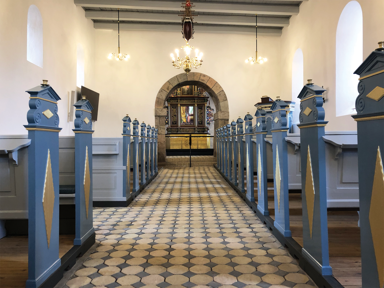 Kirkeudsmykning af Mammen Kirke med blå kirkebænke og alter, kunst af Peter Ejlerskov.